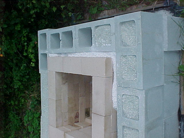 closeup of the furnace showing the backfilling of cinder blocks with kitty litter insulation and filling the void from firebricks and cinder blocks with Perlite